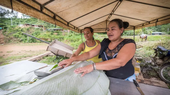 Rosa (right) and Mayerlis (left) prepare a meal of sarapa - rice and chicken wrapped in a Cachibou leaf