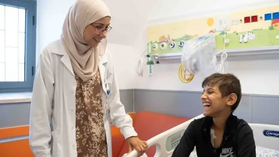 A pediatric oncologist discussing with a young boy patient at the hospital