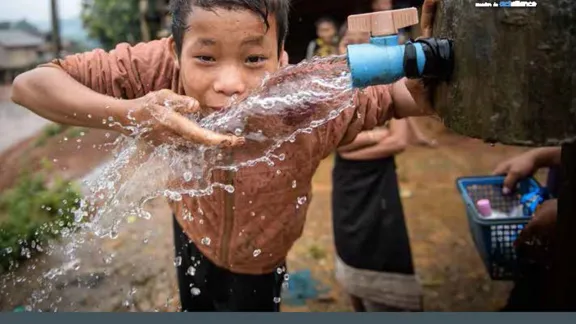 a young asian boy playing with water