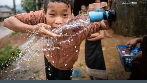 a young asian boy playing with water